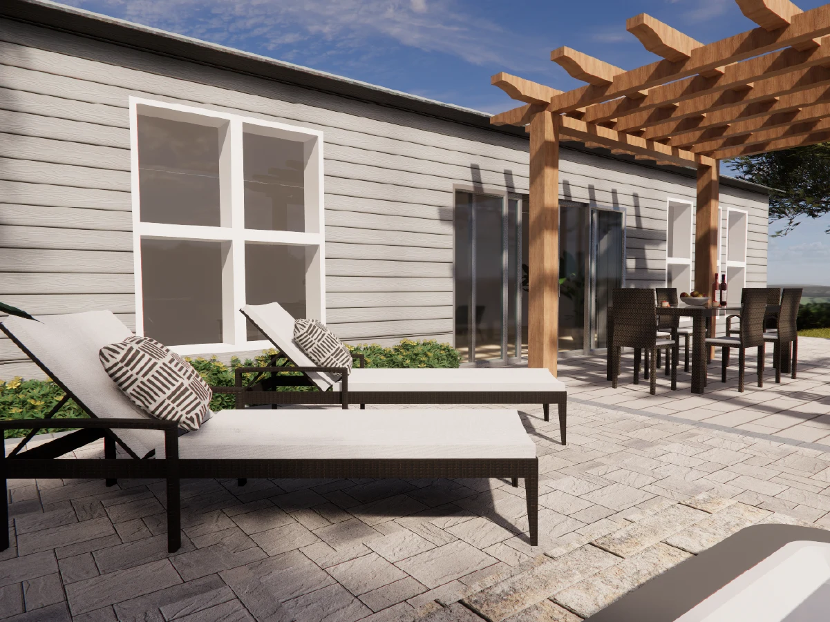 Two modern white sun loungers with patterned pillows resting on a stone paved backyard patio.